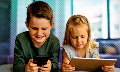 Photo of a boy and a girl using a tablet and a mobile phone